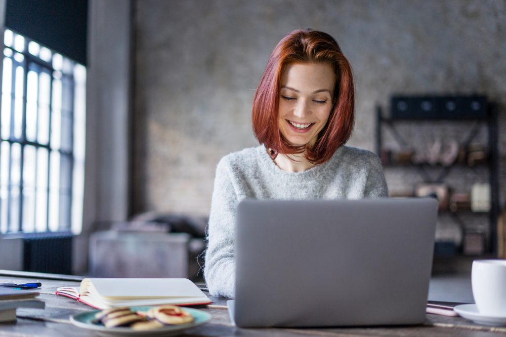 Young woman working on a laptop in a loft