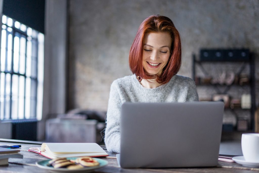 Young woman working on a laptop in a loft